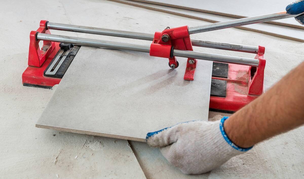 A person using a tile cutter.