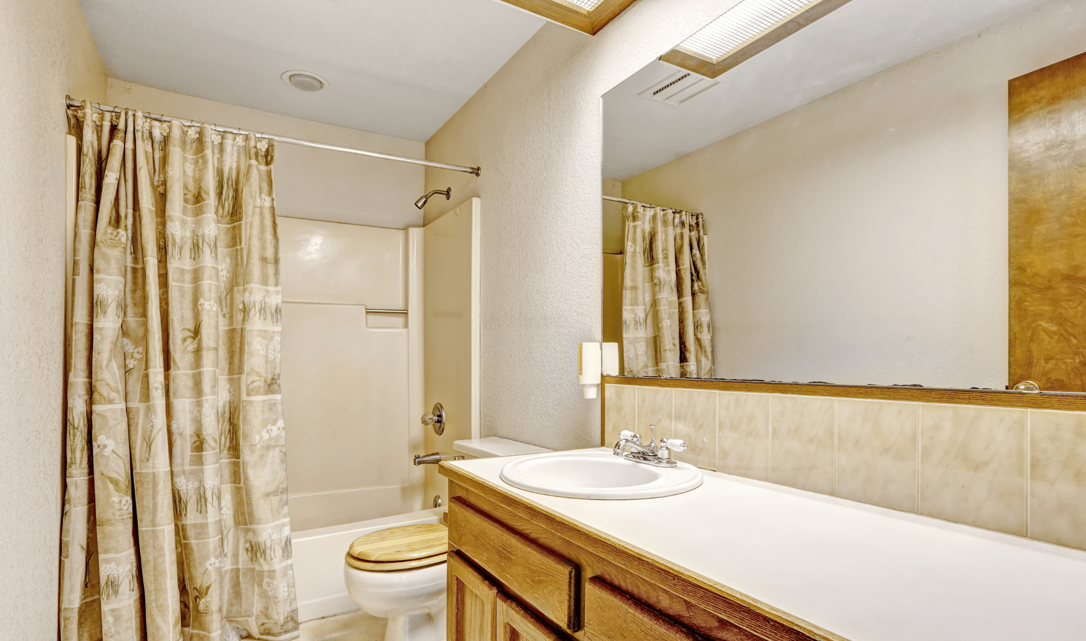 A bathroom with a huge wall-mounted mirror.