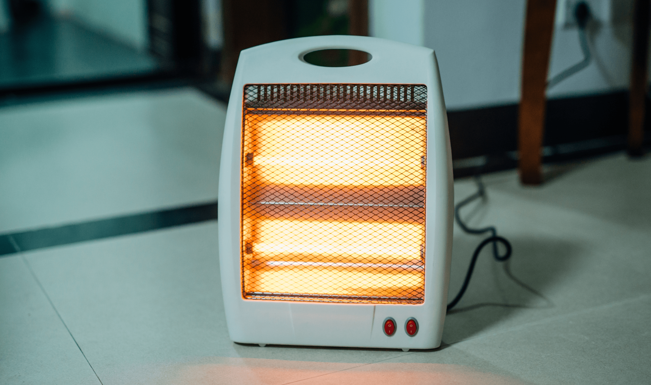 A small space heater on the floor, glowing orange with warmth.
