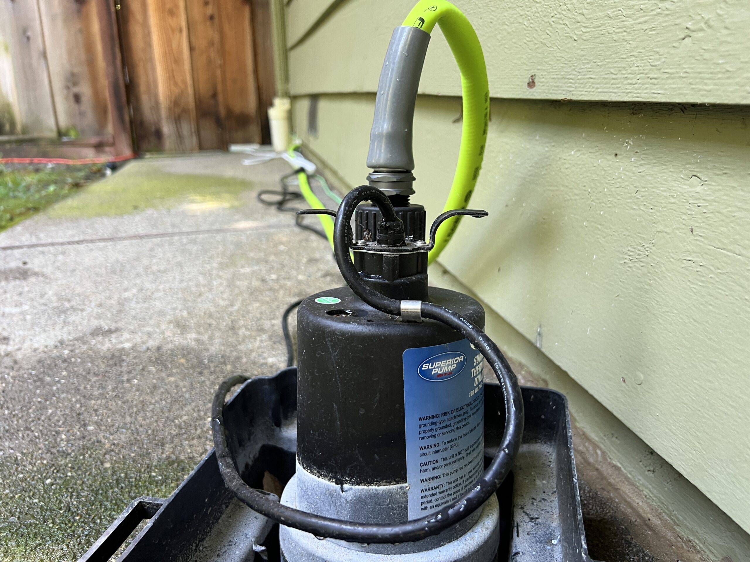 Closeup of a sump pump outside of a house.
