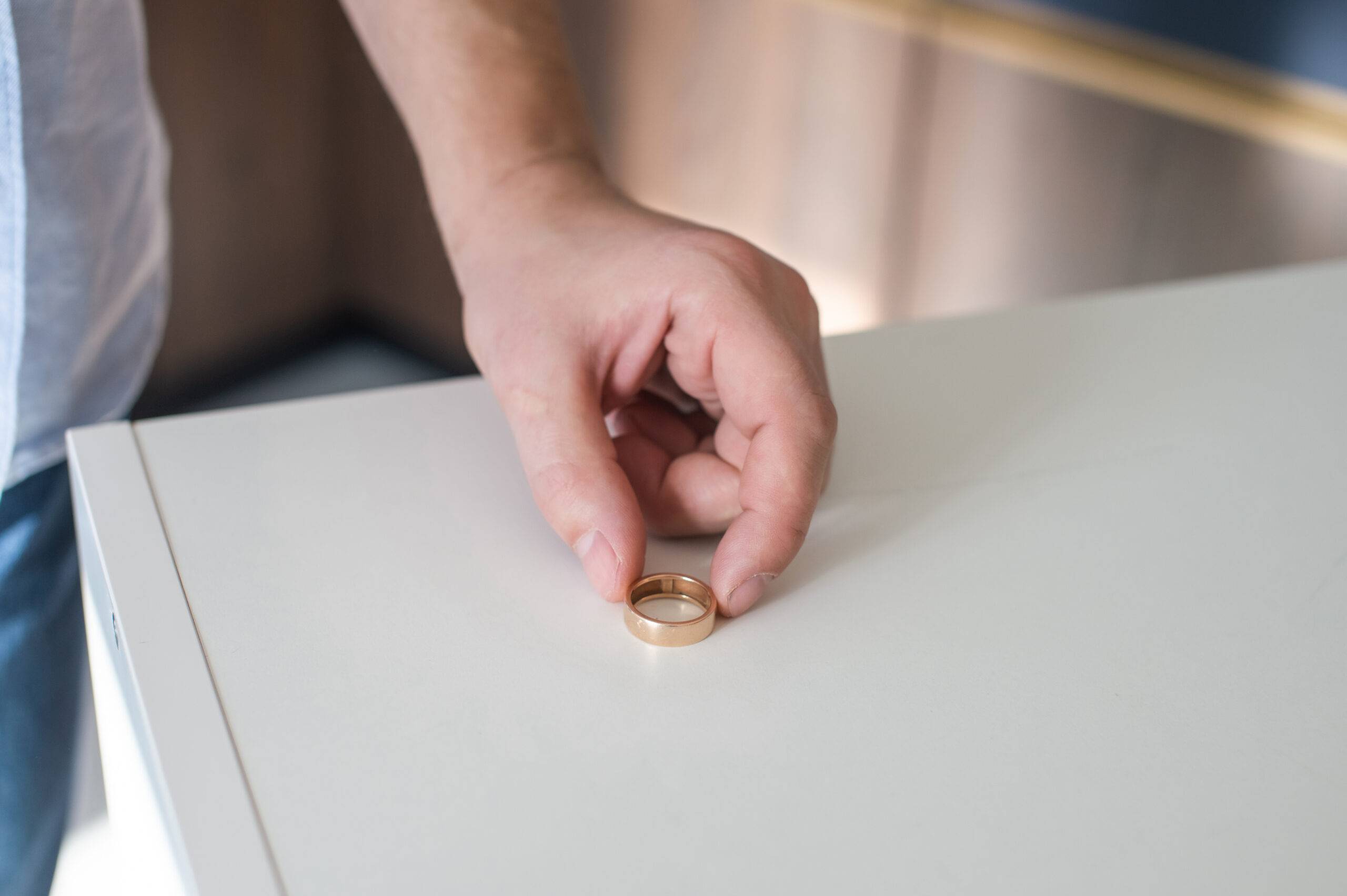 Man putting wedding ring on counter.