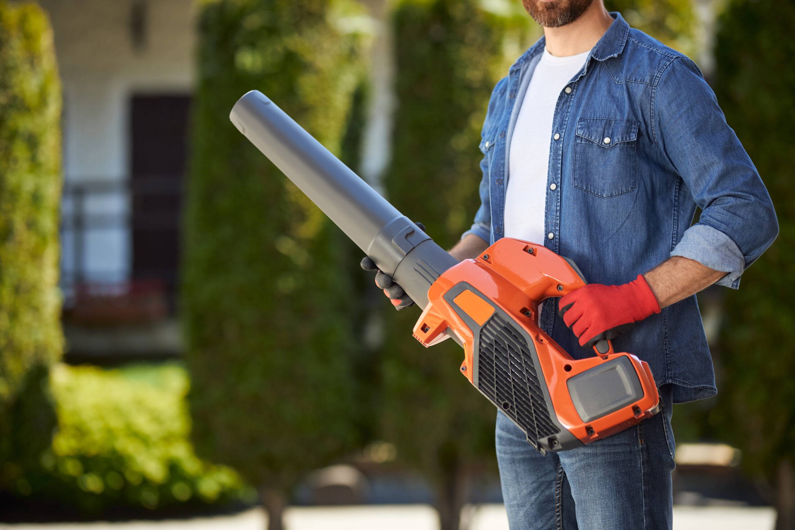 Man holding leaf blower.
