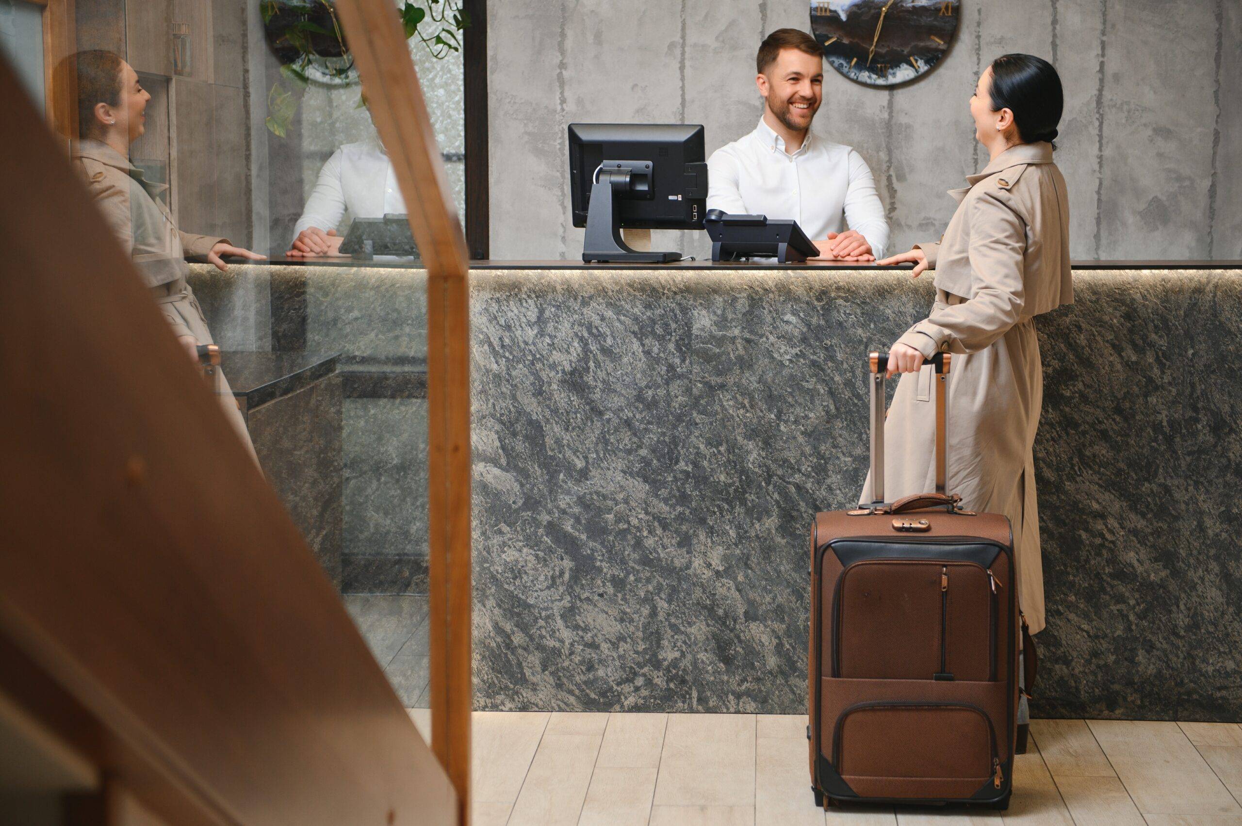 Woman checking in at the front desk of a hotel.