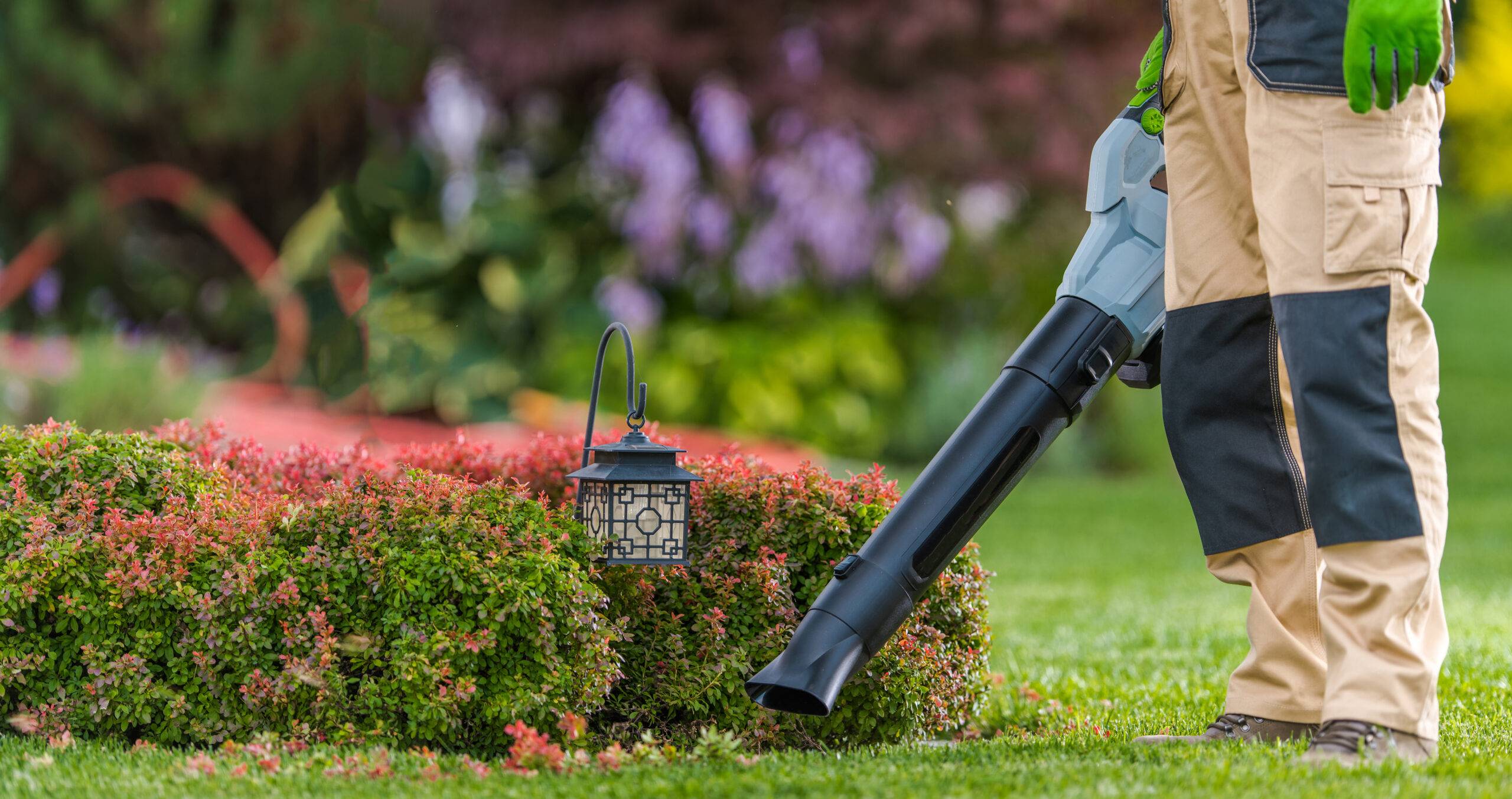 Gardener holding a leaf blower.