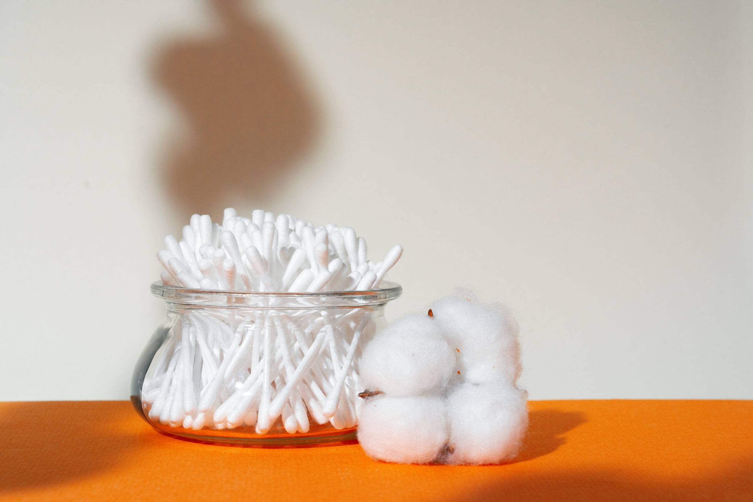 Cotton swabs and cotton balls in a container.