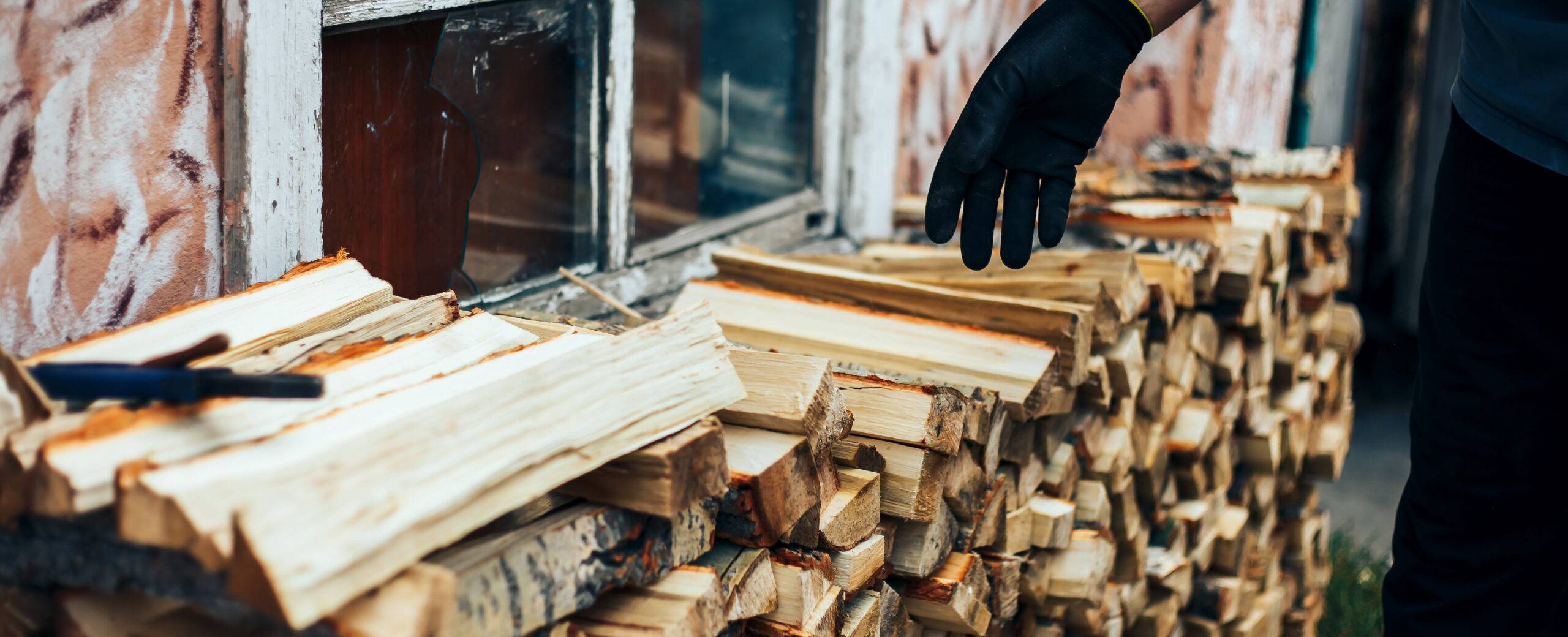 Firewood stacked near a house.