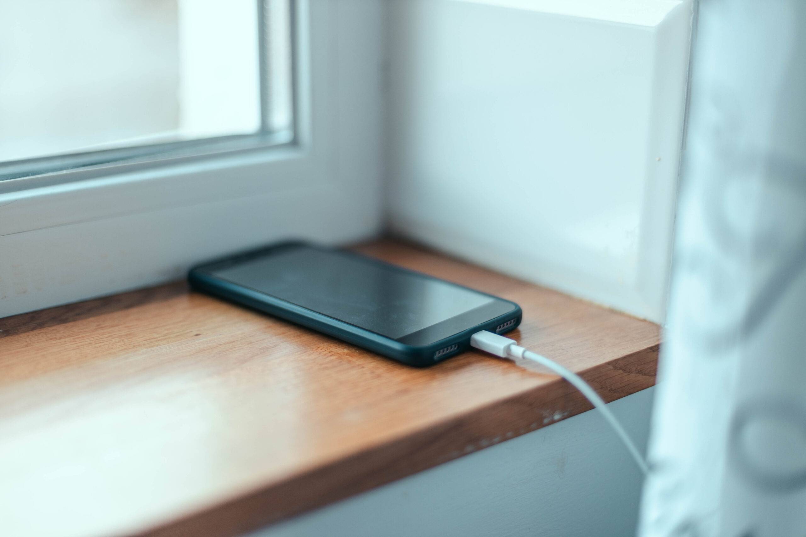 Cell phone charging on windowsill.