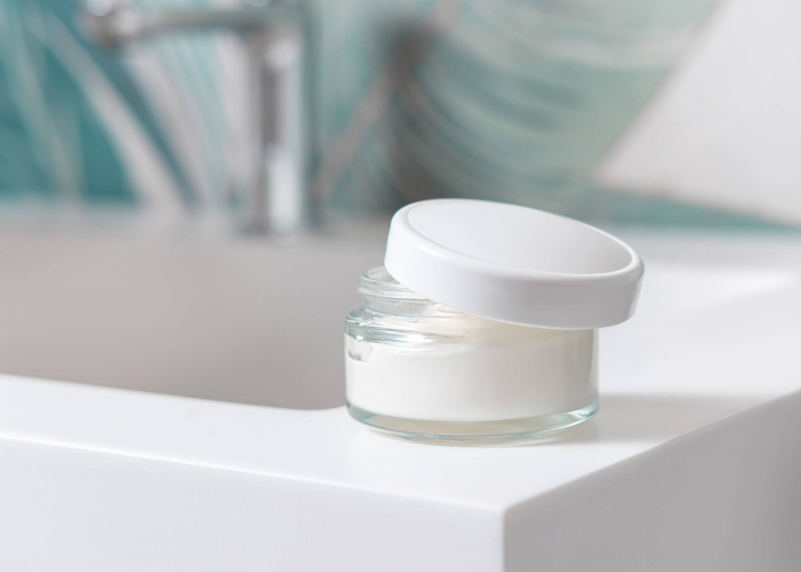 Jar of skincare on a bathroom sink.