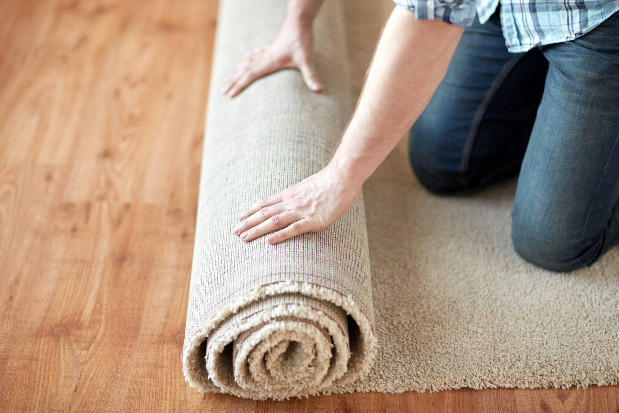 Hands rolling out carpet.