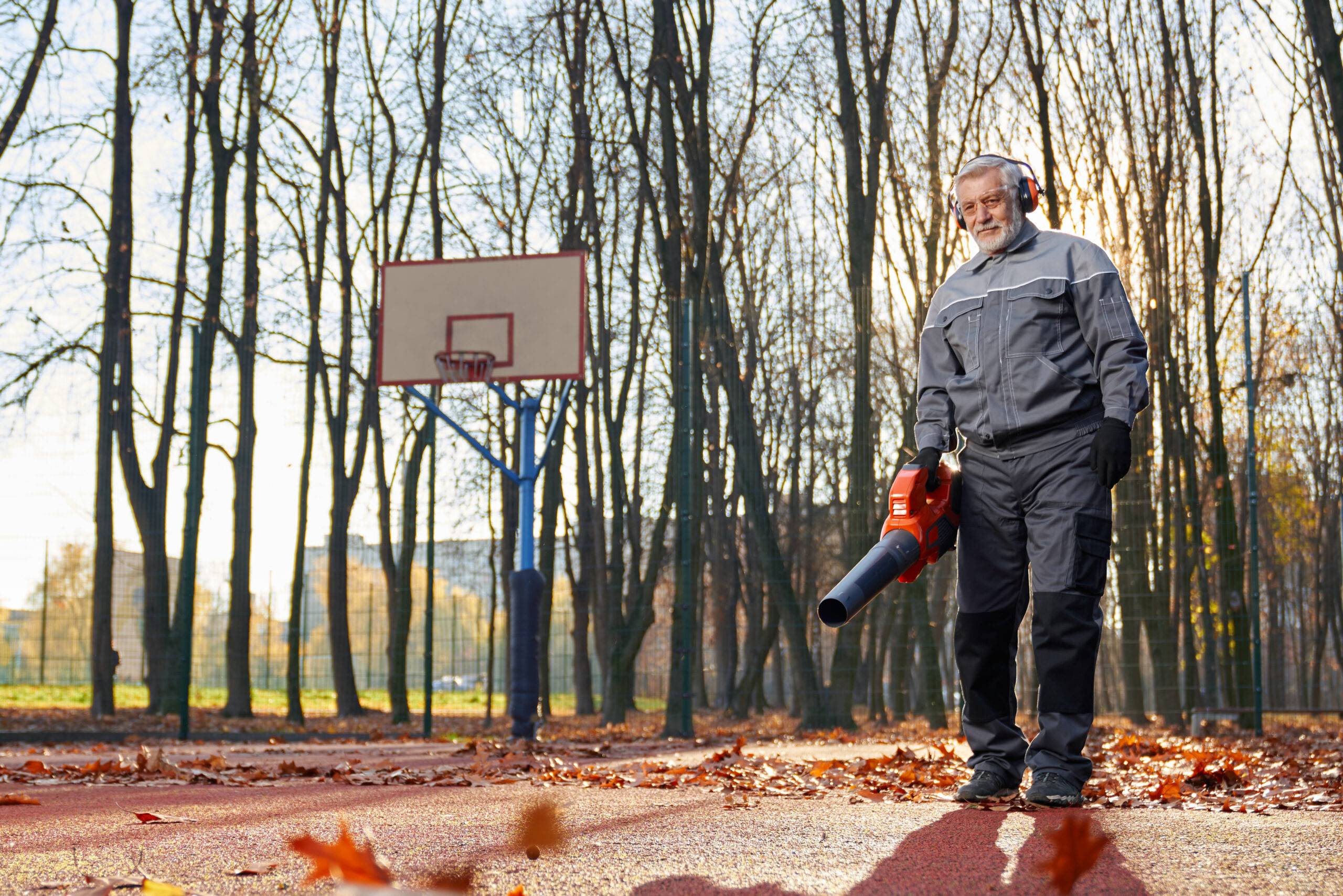 Man using leaf blower with ear and eye protection.