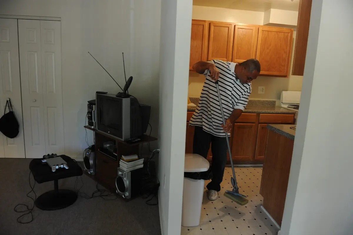 Man vacuuming his house to clean it.