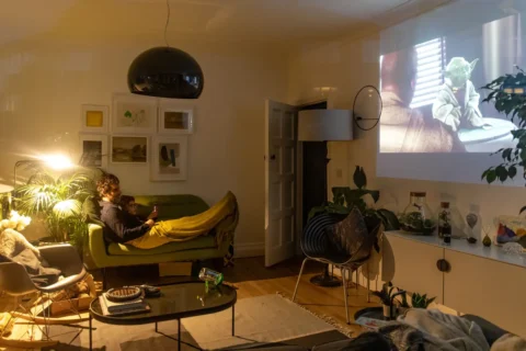 Andrew and his son Hector are seen watching Star Wars inside their home using a projector on April 04, 2020 in London.