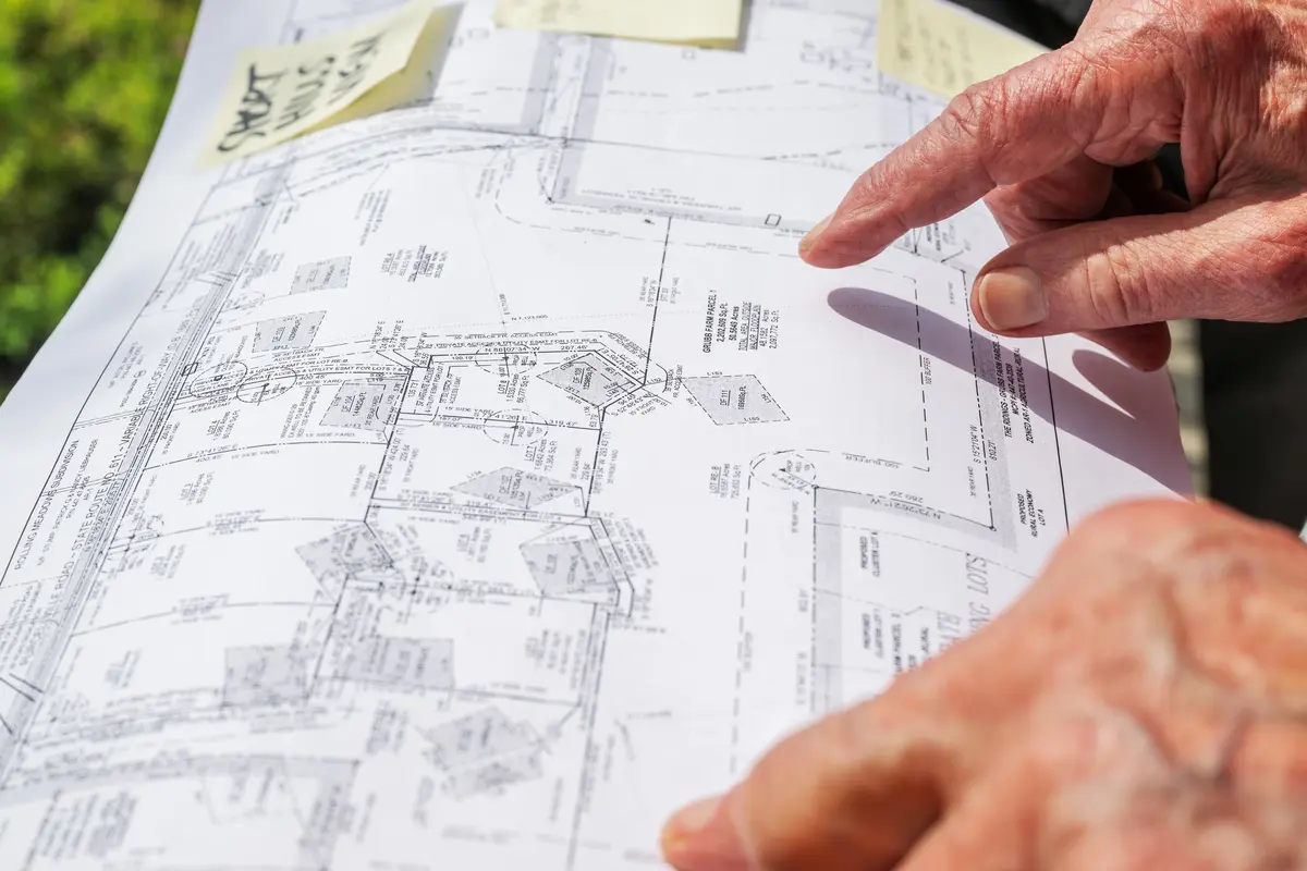 A an's hand tracing over a map of adjoining lots in Loudon County, VA on August 14, 2023.
